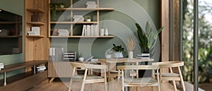 The interior design of a modern green office lounge or break room with a dining table and decor