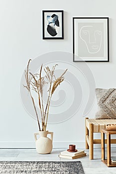 Interior design of scandinavian living room with stylish sofa, mock up poster frames, book, dried flower in vase, decoration.