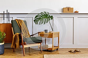 Interior design of stylish living room with vintage green armchair, wooden coffee table, furniture, grey wall, shelf, carpet.