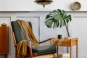 Interior design of stylish living room with vintage green armchair, wooden coffee table, furniture, grey wall, shelf, carpet.