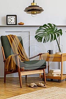 Interior design of stylish living room with vintage green armchair, wooden coffee table, furniture, grey wall, shelf, carpet.