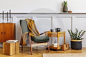 Interior design of stylish living room with vintage green armchair, wooden coffee table, furniture, grey wall, shelf, carpet.