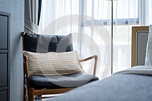 Interior design of villa, house, home, condo and apartment feature blue armchair, cushion and sheer curtain in bedroom