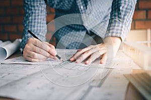 Interior designer or architect reviewing blueprints and holding