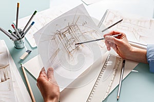 Interior designer holding hand drawing pencil sketch of a bathroom