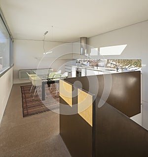 Interior detail of nmodern house in Switzerland, showing the kitchen and dining room with table and chairs