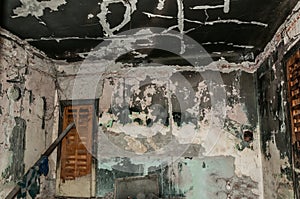 Interior of the domestic abandoned house damaged and burned in the fire accident with black soot and grime on the walls and ceilin