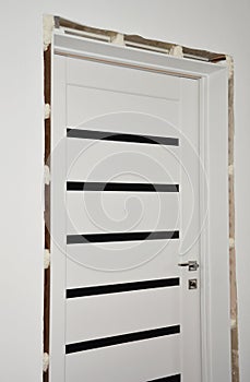 Interior door installation: Fixing and installing a door jamb, door frame filling the gaps with a foam sealant