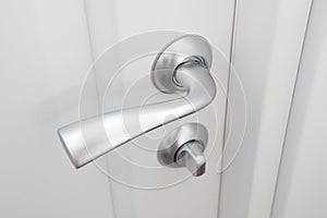 Interior doors fittings. Matte metal door handle with lock on white wooden Interior door