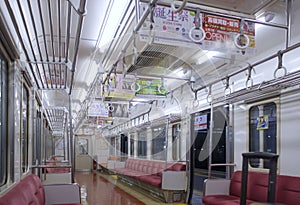 Interior of empty Japanese train wagon stop at platform of Numazu Station at night