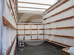 The interior of an empty removal van, with carrying trolley and packaging.