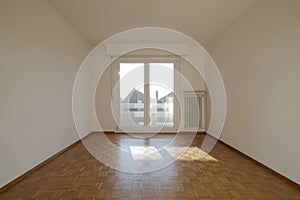 Interior of an empty room, front view with a window at the back. Large space. Nobody inside