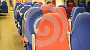 Interior of an empty train with red and blue seats
