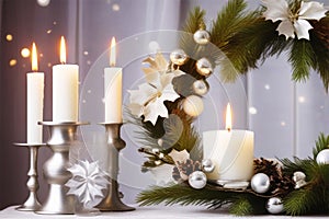 Interior festive composition with burning candles, green spruce branches and Christmas tree balls against a background of