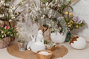 Interior floral Easter composition. Figurines of Easter bunnies and a large eggshell.