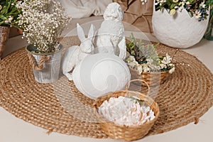 Interior floral Easter composition. Figurines of Easter bunnies and a large eggshell.