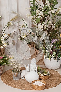 Interior floral Easter composition. Figurines of Easter bunnies and a large eggshell.