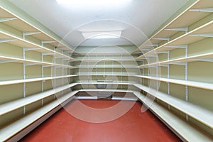 Interior of a food storage room with empty shelves at the basement