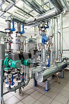 Interior gas boiler room with multiple pumps and piping