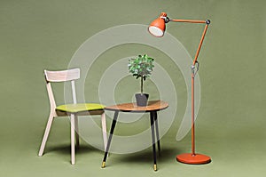 Interior with green chair, lamp, coffee table on green background