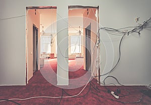 Interior of hall of apartment with temporary electric wires during upgrade or remodeling, renovation, extension