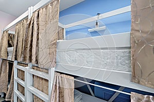 Interior of the hostel room. Bunk beds with fabric blinds