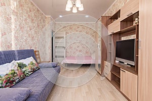 Interior of hotel room, bed, sofa, wardrobes, TV