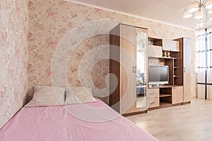 Interior of hotel room, bed, wardrobes, TV