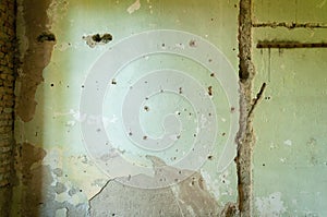 Interior house wall plaster with bullet holes and damage from shrapnel from grenade. photo