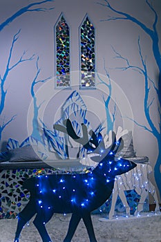 The interior of the ice castle. Two stained glass windows in the medieval style. Blue trees on the wall. Throne sofa