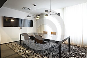 Interior of illuminated modern board room with conference table and chairs, copy space