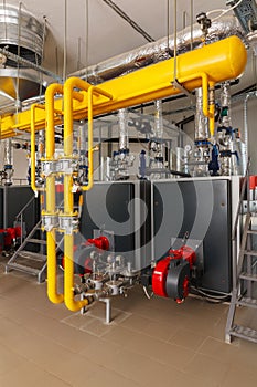 Interior of industrial gas boiler house with many pipes and boil