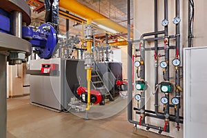 Interior of industrial, gas boiler room with boilers; pumps; sensors and a variety of pipelines photo