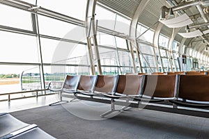Interior inside airport terminal. Lounge with chairs in waiting departure area. Summer vacation. Airplane travel concept