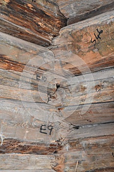 Interior joints of an old log cabin with numbers indicated it has been dissembled, moved, and reassembled an