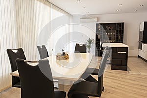 Interior of kitchen and dining room, white kitchen cabinetry and steel appliances. Interior photography. Open space living room photo