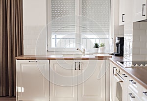 Interior of kitchen and dining room, white kitchen cabinetry and steel appliances. Interior photography. Open space living room