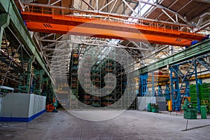 The interior of a large warehouse of heavy iron products and metal goods with pallet storage shelves at a production forge plant