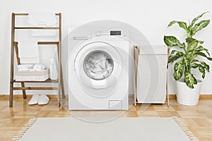Interior of laundry room with modern washing machine and textile