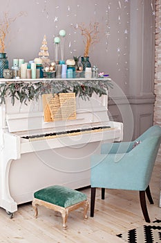 Interior living room is decorated in classic style with white piano, Christmas tree and gifts. New Year decoration. Piano in room