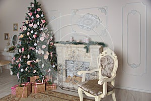 Interior of the living room with a fireplace, decorated for the New Year with a big Christmas tree and lots of presents