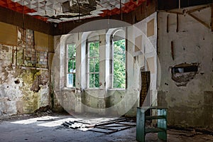 Interior of a living room with three windows of an abandoned house