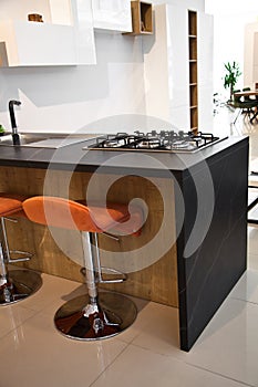 Interior of luxurious wooden modern kitchen and orange chair