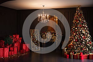 Interior of luxury dark living room with fireplace and chandelier decorated with Christmas tree and gifts