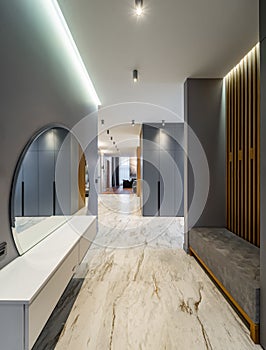 Interior of luxury house. Grey tones. Entrance hall. Round mirror