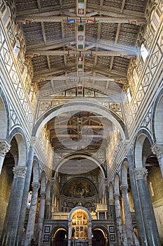 Interior of the medieval church of San Miniato in Florence with stone walls and decorated wooden ceiling