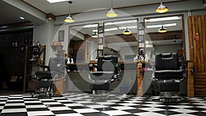 Interior of the men`s Barber shop with brick walls and leather chairs with chrome handles