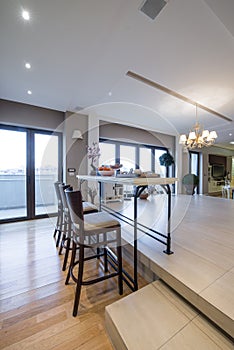 Interior of a modern apartment with bar table and chairs