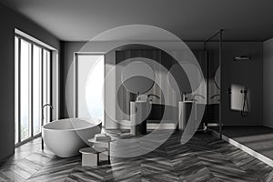 Interior of modern bathroom with grey wooden walls, parquet floor, two sinks with two round mirrors above it and comfortable white