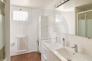 Interior of a modern bathroom in light tones with shower reflected in a big mirror